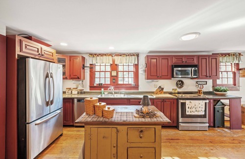 Holderness House | Central Escape is a spacious Lakes Region retreat just 5 minutes from downtown Meredith, less than a mile to Squam Lake and 20 minutes to concerts at the Bank of New Hampshire Pavilion. Enjoy the private year-round hot tub, fire pit, yard games!