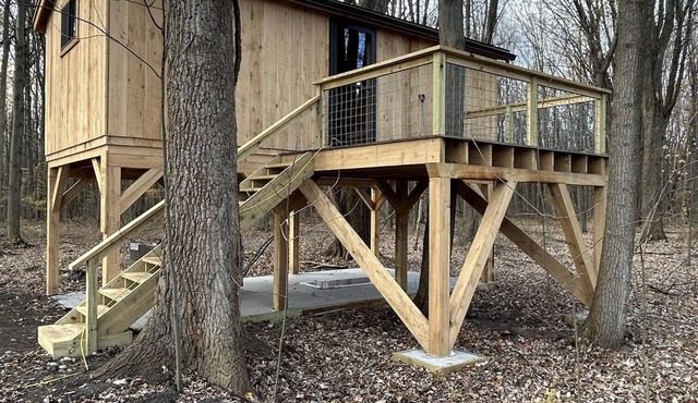 Timber framed tree cabin nestled in the woods.